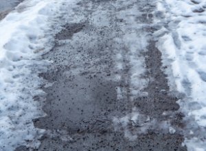 Splitt-Streuung am vereisten Gehweg